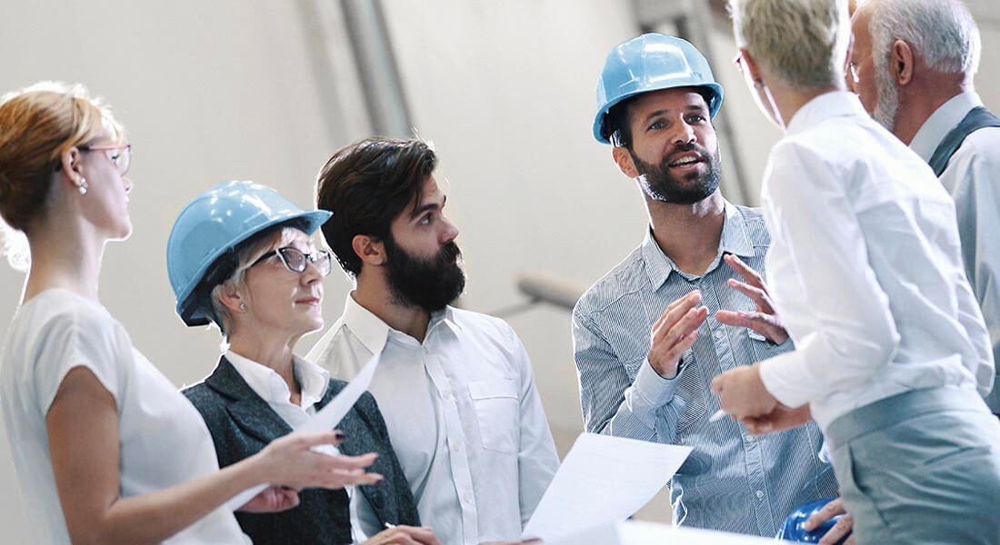 Team of experts on a construction site discuss construction details.