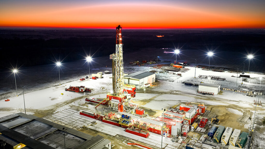 Drill rig with snowy ground and sunrise